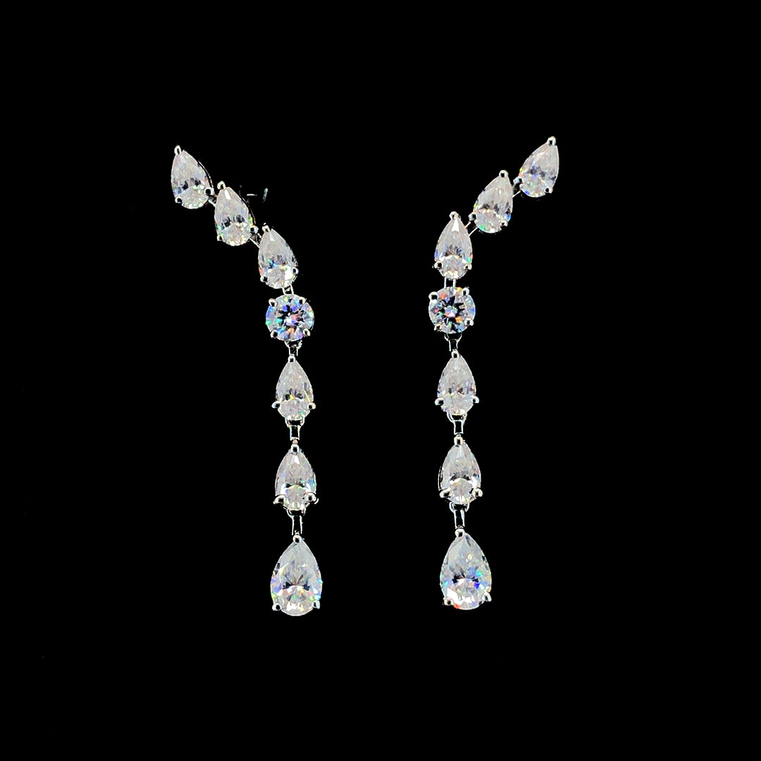 A pair of sterling silver earrings featuring a flowing pattern with seven moissanite stones in different cuts.
