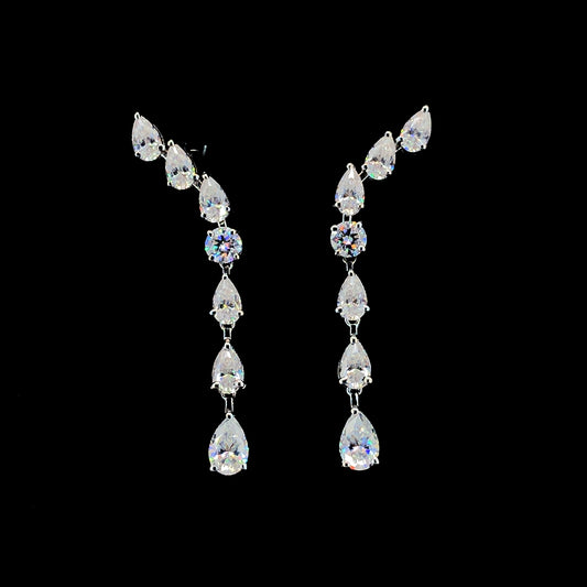 A pair of sterling silver earrings featuring a flowing pattern with seven moissanite stones in different cuts.