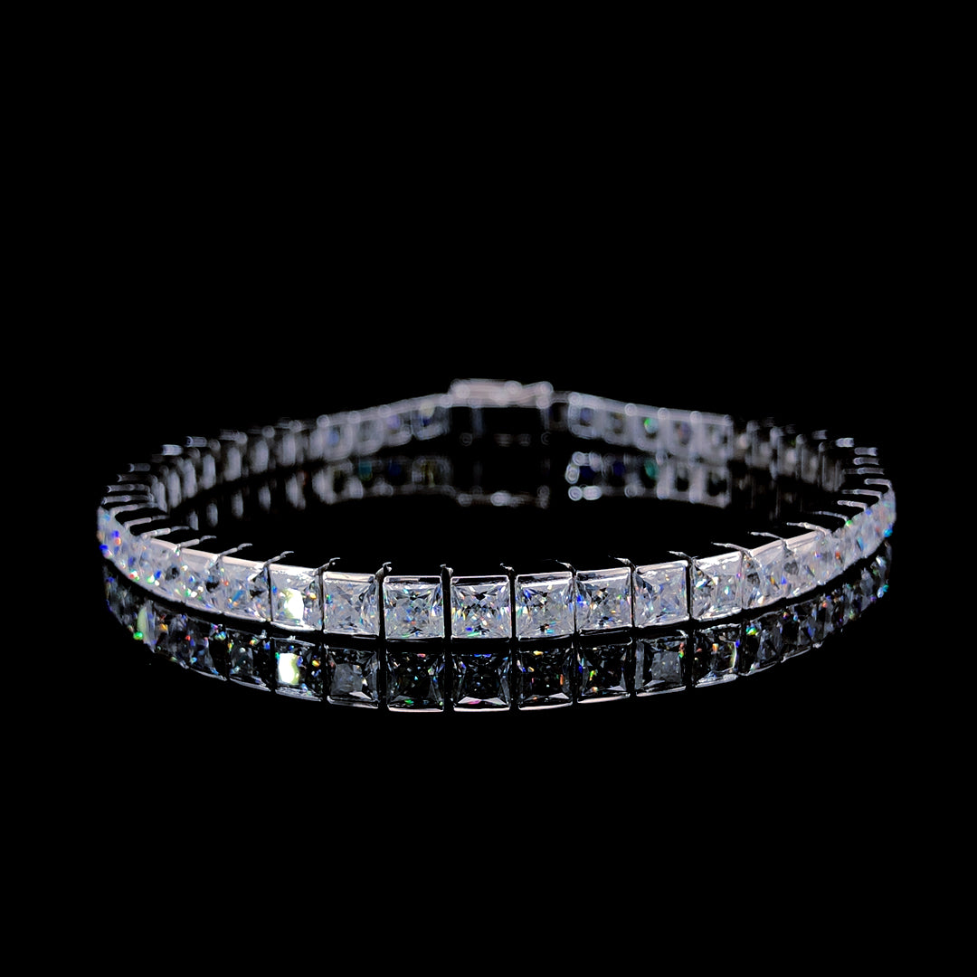 A tennis bracelet with princess-cut moissanite stones set in polished sterling silver.